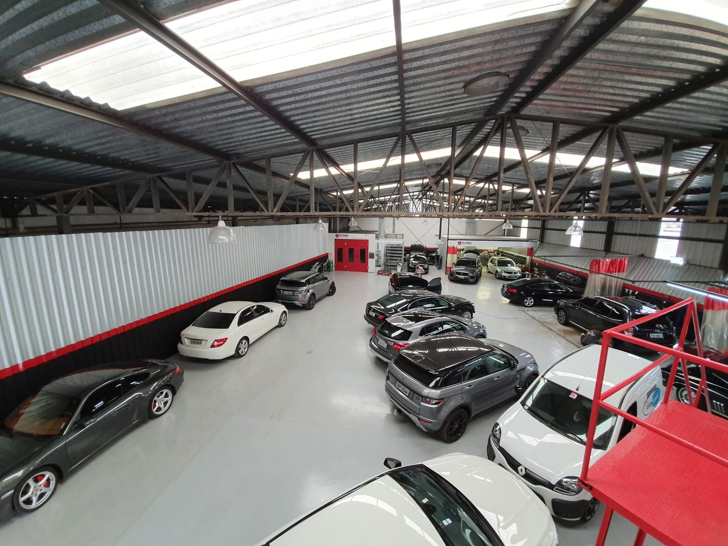 Oficina automotiva premium limpa com carro de alto padrão em manutenção